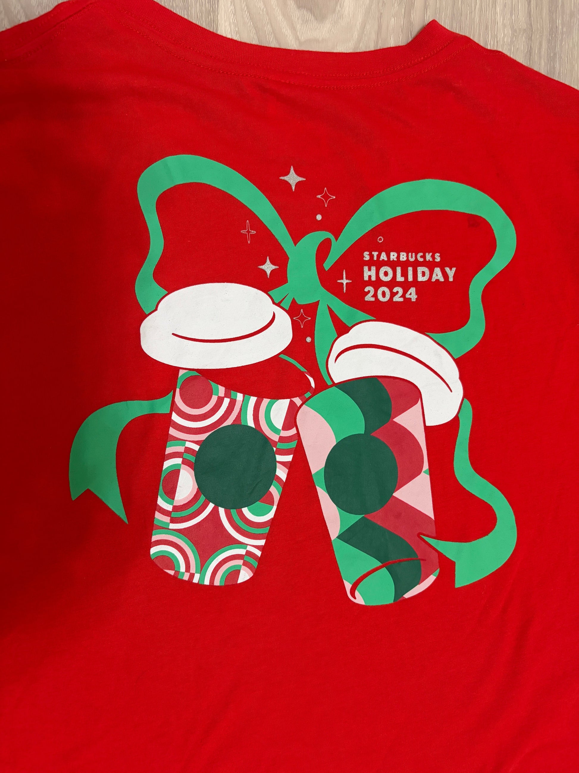 Leox Hub Starbucks Japan 2024 Holiday staff t-shirt in red with festive coffee cup and green ribbon graphic on back